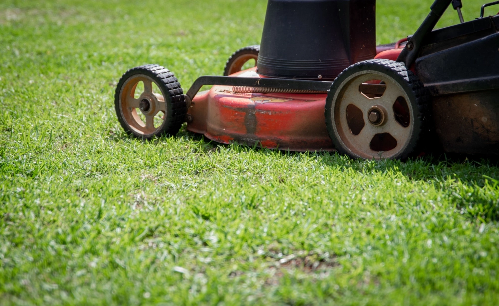 Lawn mower cutting a residential grass lawn.
